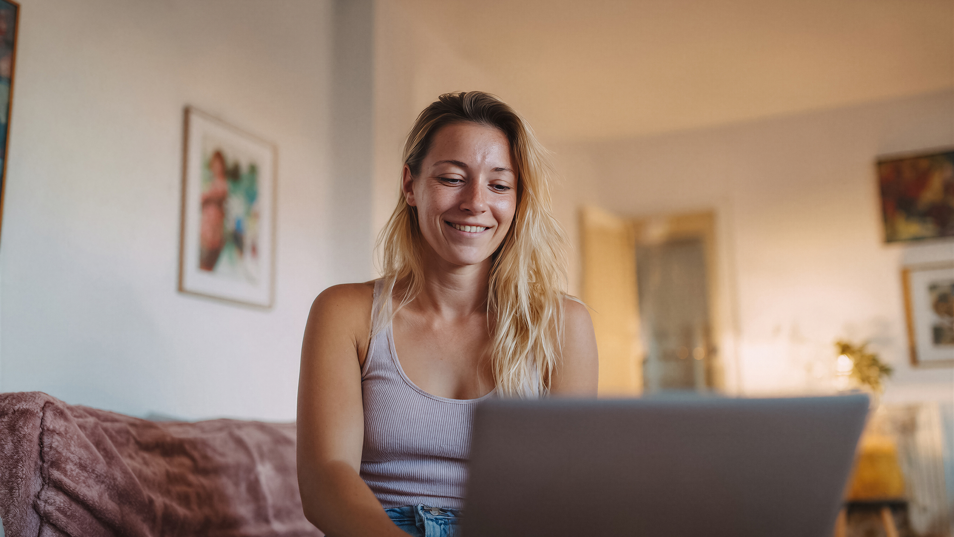 Une femme souriante devant son ordinateur